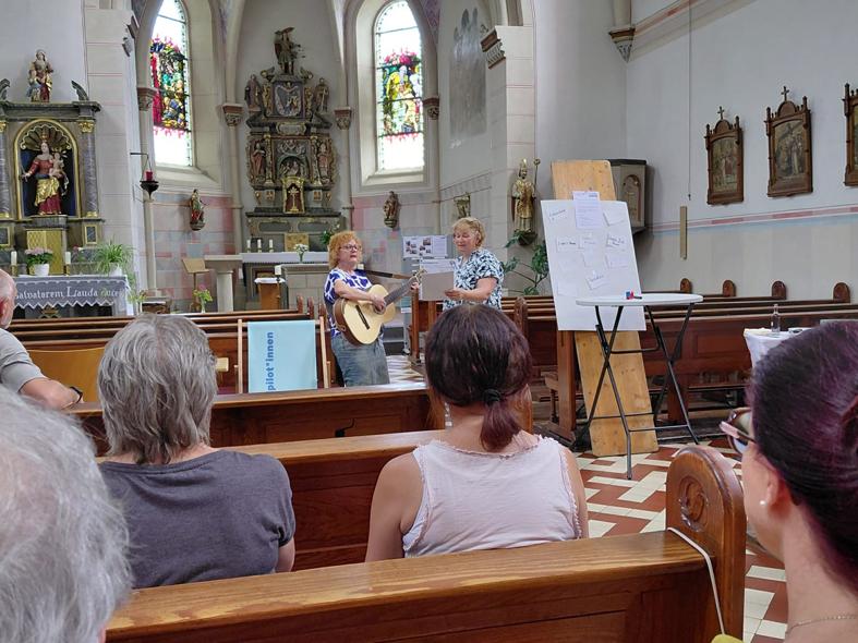 Gäste in den Bänken der Kirche hören dem Gesang zu